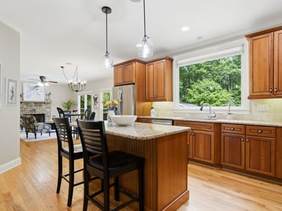 Bright and functional kitchen featuring wooden cabinetry, granite countertops, and a spacious island perfect for gatherings.