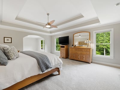 Spacious master bedroom featuring natural light, a cozy atmosphere, and modern amenities for ultimate relaxation.