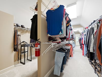 Spacious walk-in closet featuring abundant shelving for organized storage and natural light from skylights.