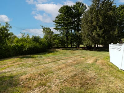 Spacious yard with mature trees, offering ample room for outdoor activities and gardening possibilities.