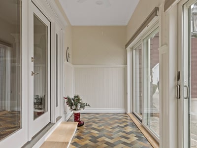 Bright entryway featuring unique herringbone floors, large windows, and ample natural light, ideal for welcoming guests.