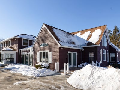 Spacious multi-level home featuring ample parking, surrounded by winter scenery, perfect for year-round living.