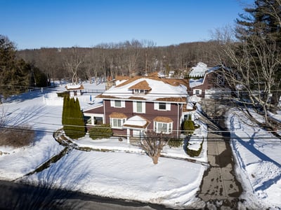 Spacious home on a large lot, featuring expansive outdoor areas and nearby wooded surroundings.