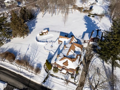 Spacious property with picturesque winter scenery, featuring a unique layout and ample outdoor space for recreation.