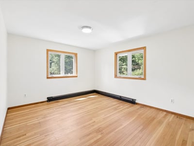 Spacious room with abundant natural light and hardwood flooring, perfect for customizing your ideal living space.