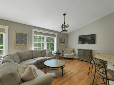 Bright and inviting living area features large windows, cozy seating, and a seamless flow to outdoor space.