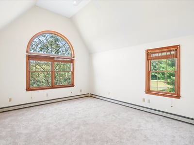 Bright and airy bedroom featuring large windows that invite abundant natural light and picturesque views.