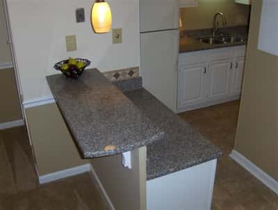 This kitchen features a convenient breakfast bar with granite countertops, perfect for casual dining or entertaining.