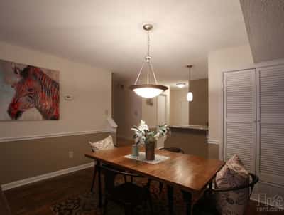 Bright dining area with modern lighting and unique art, perfect for casual meals or entertaining.