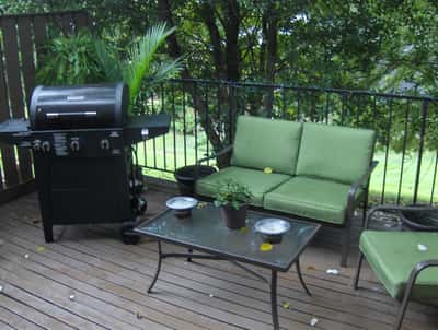 Enjoy outdoor gatherings on this inviting deck featuring a grill and comfortable seating for relaxation.