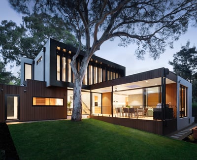 Stunning modern home featuring expansive windows, sleek design, and lush greenery for a serene living experience.