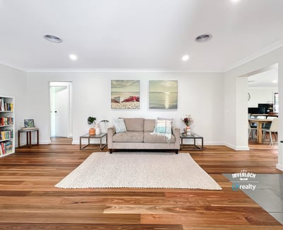 Bright and spacious living area featuring warm wooden floors, modern artwork, and an inviting atmosphere.