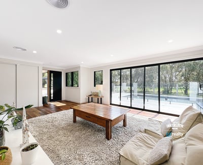 Spacious living area features large windows, abundant natural light, and direct access to outdoor spaces.