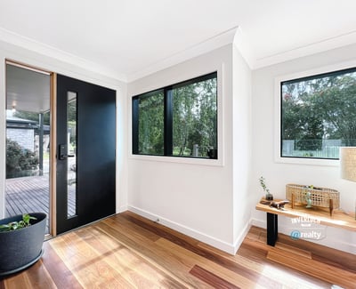 Bright entryway featuring large windows and natural light, welcoming you into a spacious home.