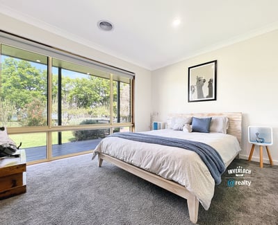 Bright and airy bedroom featuring large windows that invite natural light and offer picturesque garden views.