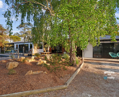 Contemporary home surrounded by lush landscaping, featuring spacious outdoor areas and modern design elements.