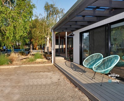 Discover this contemporary home featuring inviting outdoor seating and a spacious yard, perfect for entertaining.