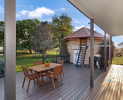 Spacious outdoor deck with direct access to lush greenery, ideal for entertaining and relaxation.