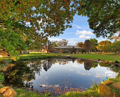 Expansive outdoor space featuring a tranquil pond, surrounded by lush greenery and scenic views.
