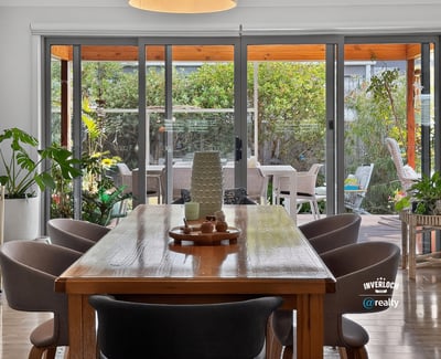 Bright dining area opens to a lush outdoor space, perfect for gatherings and entertaining.