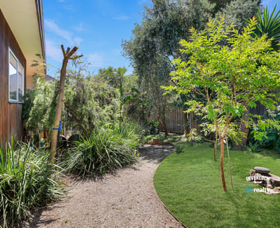 This property features a private garden oasis with lush plants and a peaceful outdoor seating area.