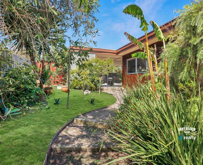 Lush landscaped garden with diverse plants and a cozy patio, perfect for outdoor gatherings and relaxation.