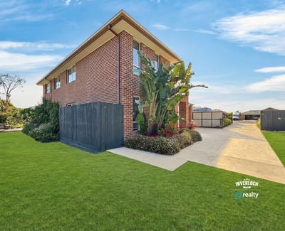 Spacious two-story home with ample outdoor space, lush landscaping, and convenient parking in a welcoming neighborhood.