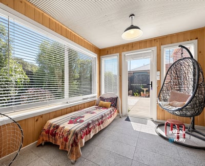 Bright and inviting sunroom features large windows, perfect for relaxing or enjoying morning coffee.