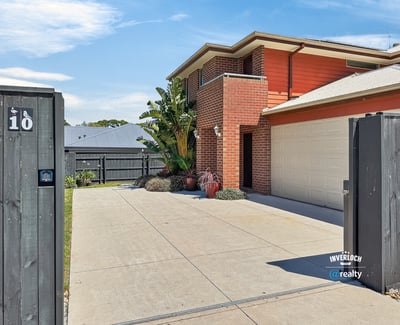 Modern home with a spacious driveway, vibrant landscaping, and convenient access to outdoor amenities.