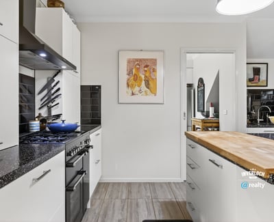 Modern kitchen featuring sleek appliances, ample counter space, and distinct artwork for a vibrant touch.
