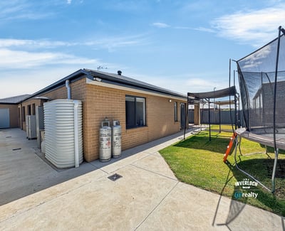 Modern home featuring spacious outdoor area with trampoline, perfect for family gatherings and playtime.