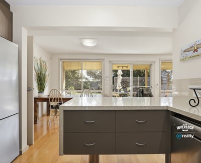 Bright kitchen with modern finishes, open to a sunlit dining area, ideal for entertaining.