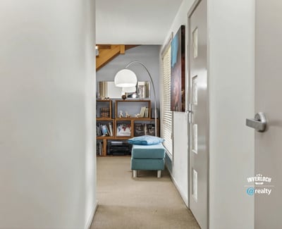 Bright and inviting hallway leads to an open living area, showcasing ample shelving and natural light.