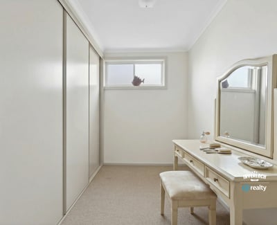 Bright and spacious room featuring ample storage and a versatile vanity area, perfect for personal retreat.