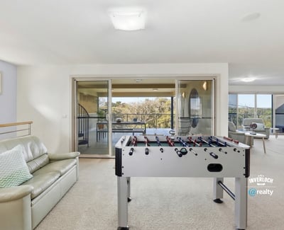 Spacious recreational area with a foosball table and large windows showcasing captivating outdoor views.