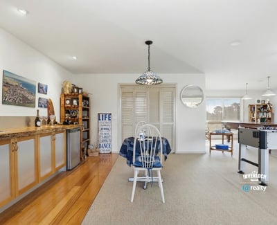 Spacious open-concept living area with natural light, functional bar, and leisure space for entertaining.