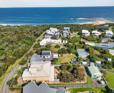 Stunning coastal property with expansive ocean views, surrounded by lush greenery and spacious outdoor areas.