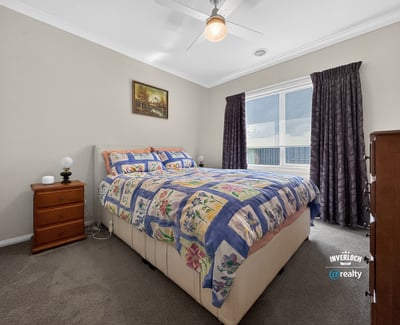 Bright bedroom featuring a spacious layout, large window for natural light, and cozy furnishings.
