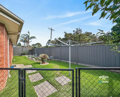 Spacious outdoor area with a fenced yard, perfect for relaxing or gardening on sunny days.