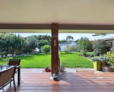 Spacious outdoor patio overlooking a vast, well-maintained garden ideal for entertaining and relaxation.
