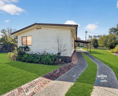 Modern home featuring a spacious yard and inviting pathway, perfect for outdoor entertaining and relaxation.