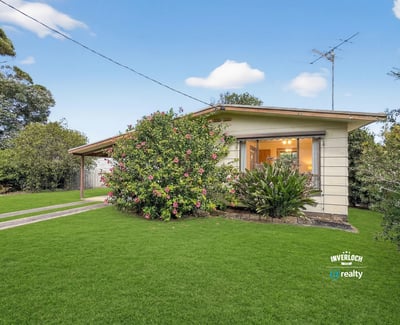 This inviting home features expansive gardens and a welcoming porch, perfect for outdoor relaxation and gatherings.