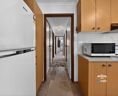 Spacious kitchen leads to ample hallway, offering convenient access to multiple rooms in this inviting home.