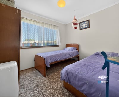 Bright and inviting bedroom featuring twin beds, large window, and ample natural light throughout.