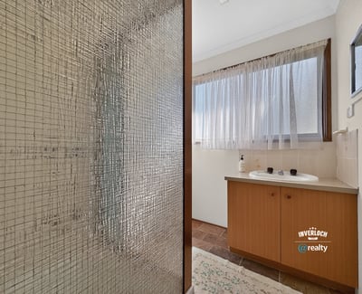 Bright bathroom featuring a spacious layout, large window for natural light, and practical design elements.