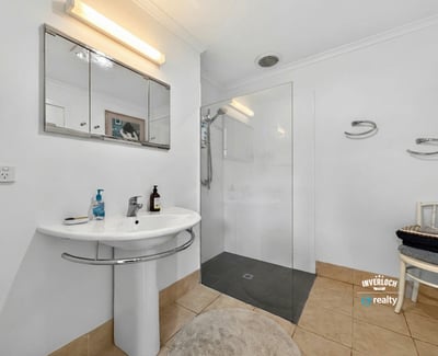 Modern bathroom featuring a glass shower, sleek fixtures, and ample natural light for a bright atmosphere.