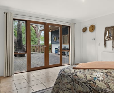 Bright and spacious bedroom with large sliding doors opening to a private outdoor deck area.