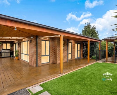 Modern outdoor living area featuring wooden decking, perfect for entertaining in a scenic, landscaped environment.