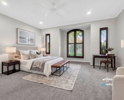 Spacious bedroom featuring large windows, plush carpet, and ample natural light for a cozy atmosphere.