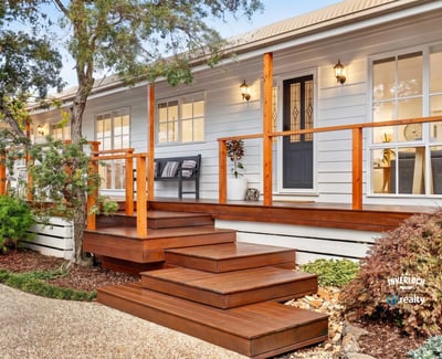 Experience modern living in this inviting home featuring a spacious deck, lush landscaping, and abundant natural light.